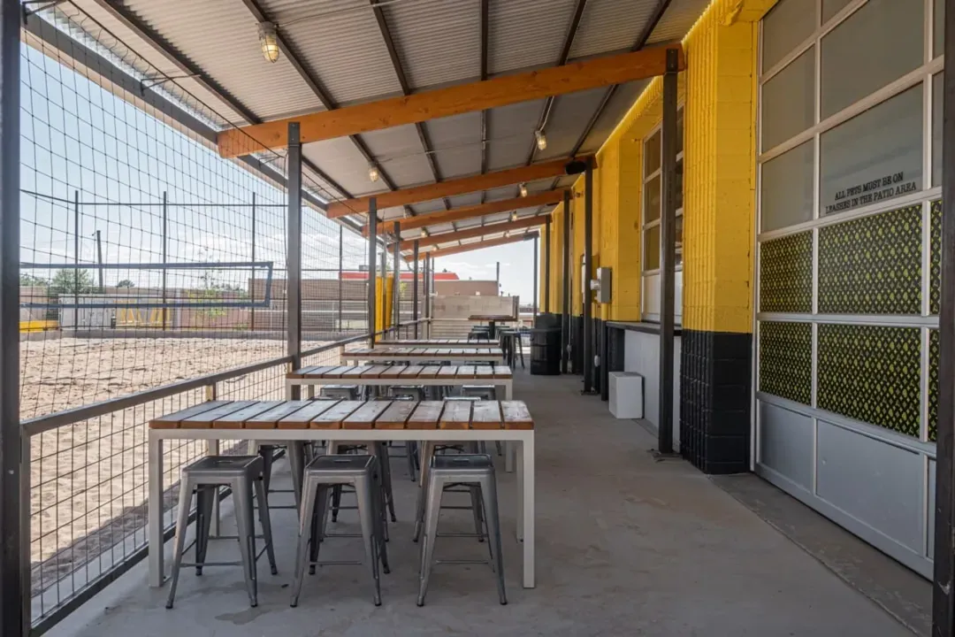 Covered volleyball court seating behind building.