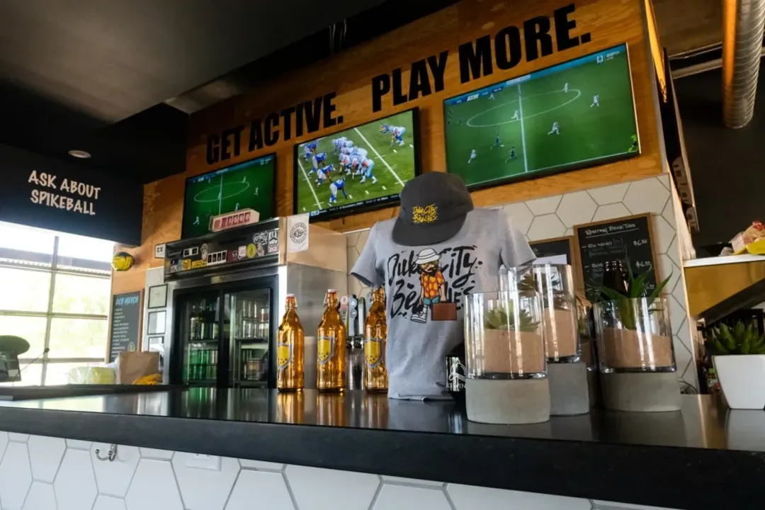Ordering counter with merch and TVs set to sports stations.