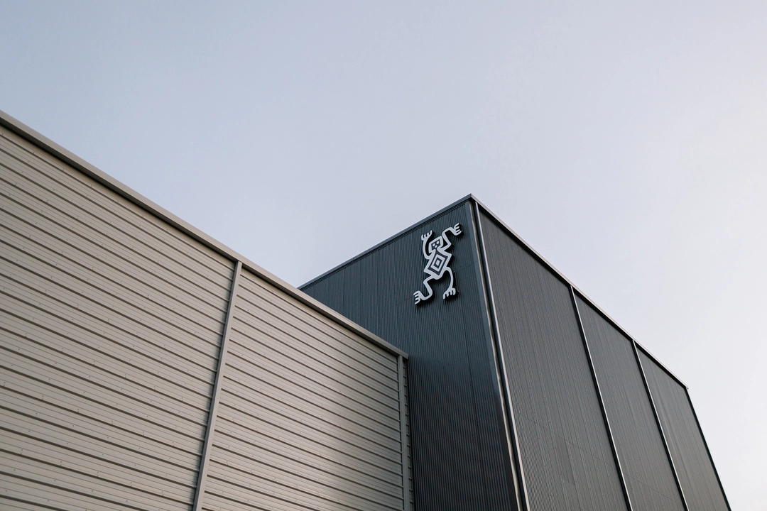 Sessions Climbing logomark on upper corner of dark panel building structure.