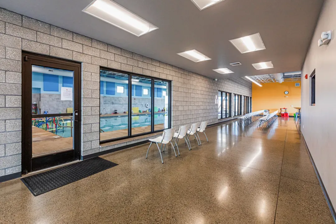 Rows of chairs facing windows to the main swimming pool area.