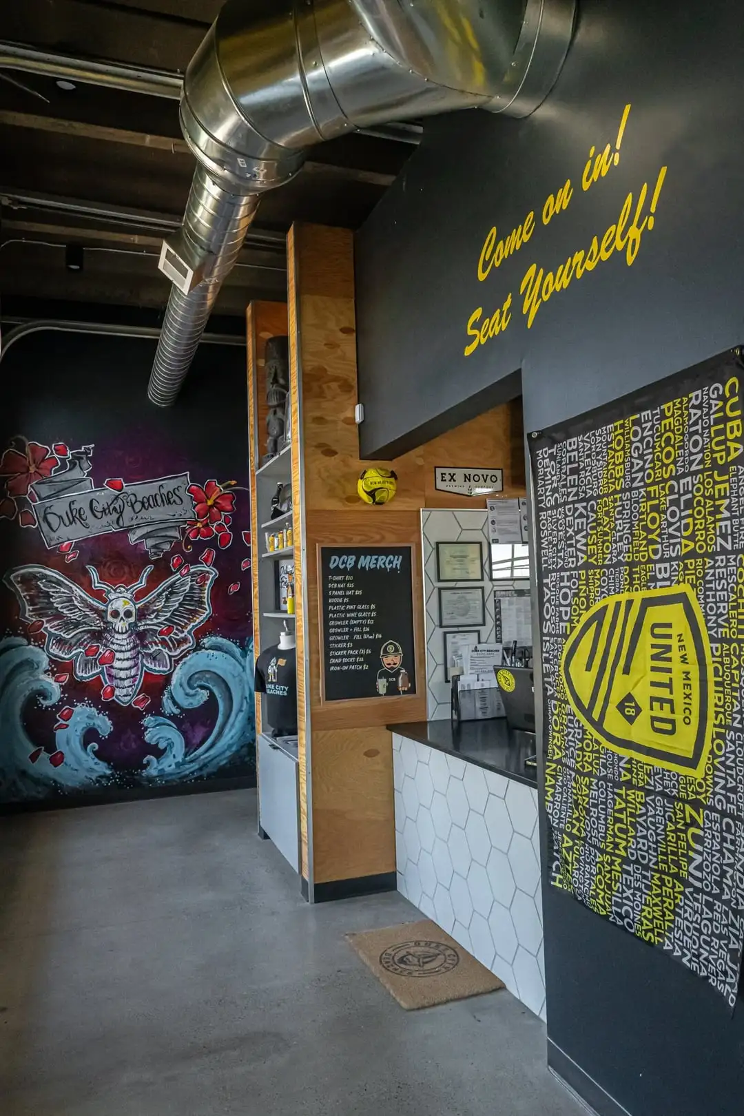 Ordering counter next to walls with NM United poster and mural.