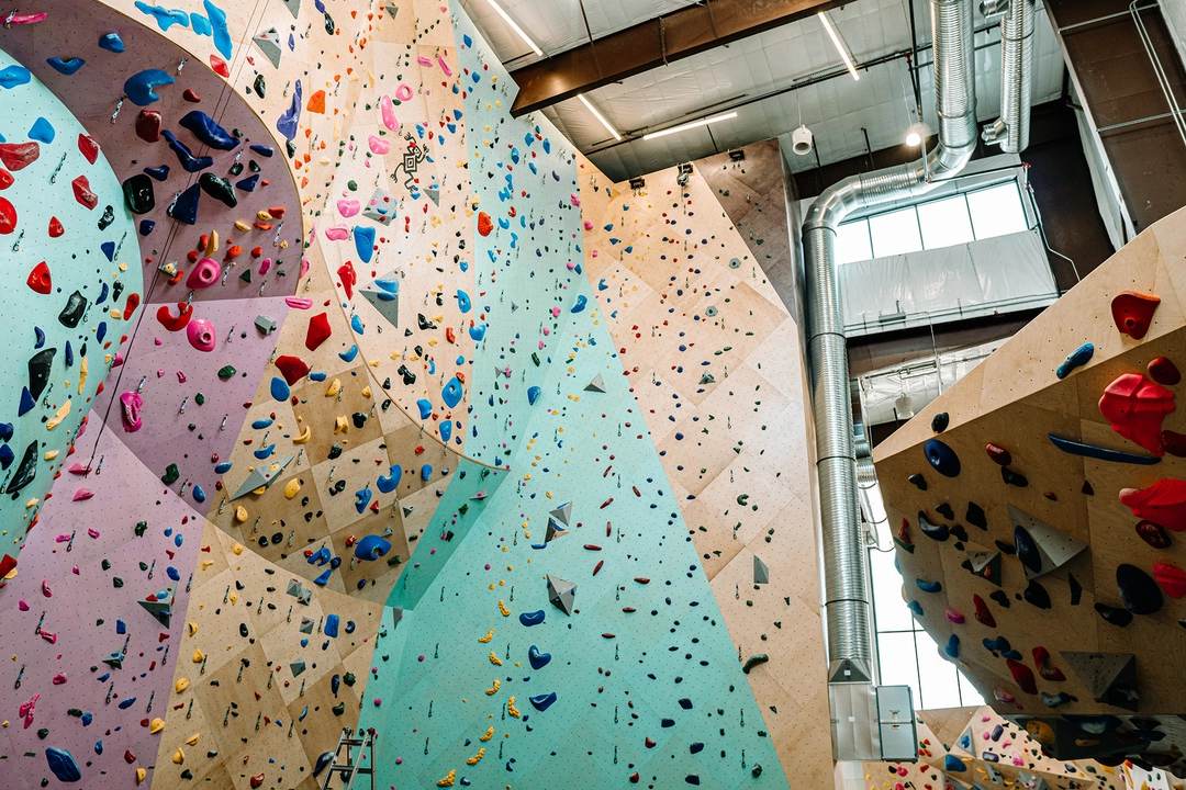 Multi-colored climbing wall with partial view of bouldering wall.