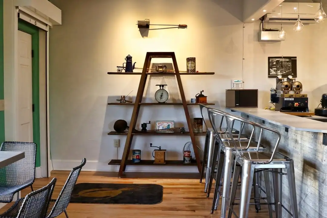 Pyramid shaped support for shelves with antique coffee-making equipment such as hand grinders and scales.