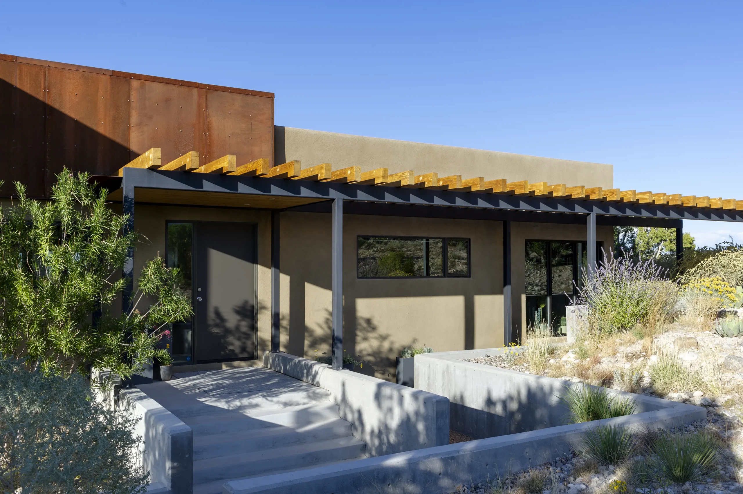 Front of modern home with steel and wood pergolas